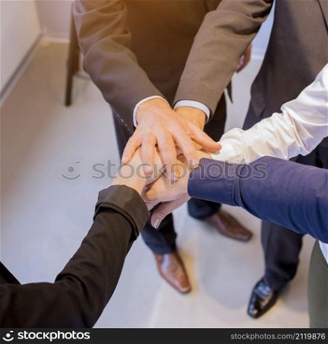 close up businesspeople stacking hands meeting office