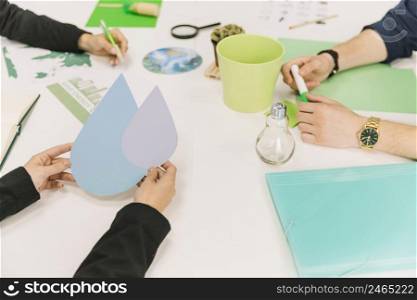 close up businessperson s hand holding water drop symbol