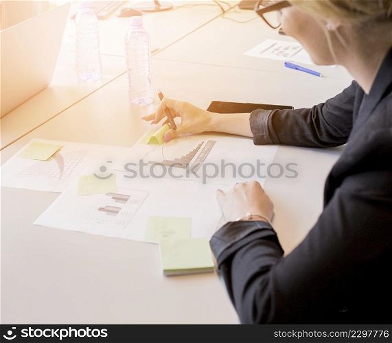 close up businesswoman looking sticky notes graph