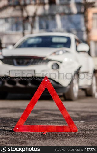 Close up car emergency stop sign on the road. Car accident or accident. The front fender and right headlight are broken, damaged and scratched on the bumper.. Close up car emergency stop sign on the road. The front fender and right headlight are broken, damaged and scratched on the bumper.