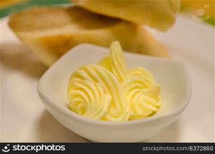 close up cheese in white bowl in front of slice of bread