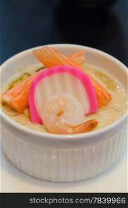 close up chinese steamed egg with seafood in white bowl