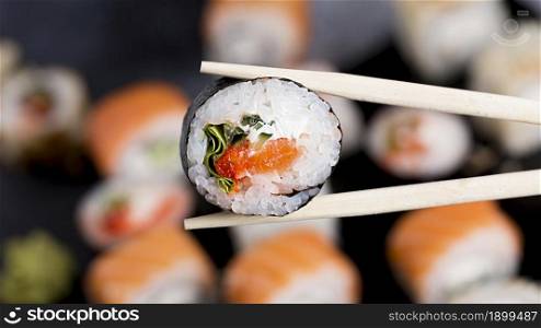 close up chopsticks with sushi roll. Resolution and high quality beautiful photo. close up chopsticks with sushi roll. High quality beautiful photo concept