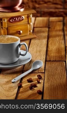 close-up coffee cup and grinder on wooden table