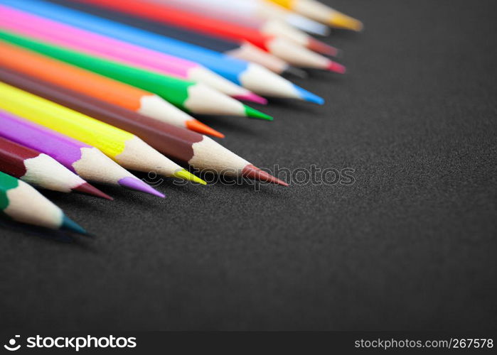 Close-up colorful pencils, crayon with selective focus on brown color on glitter black background with copy space. Back to school concept, Drawing concept.