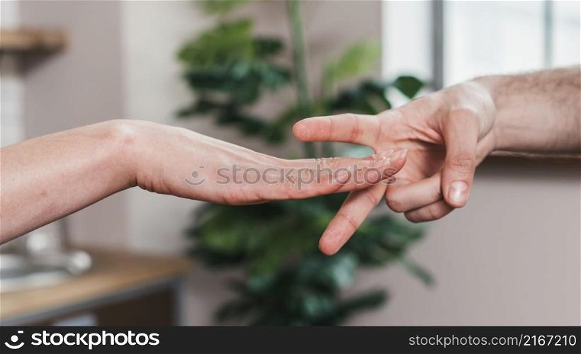 close up couple playing rock paper scissors game