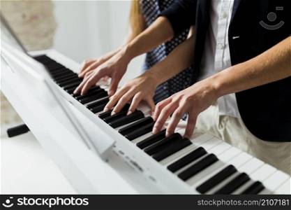 close up couple s hand playing piano keyboard