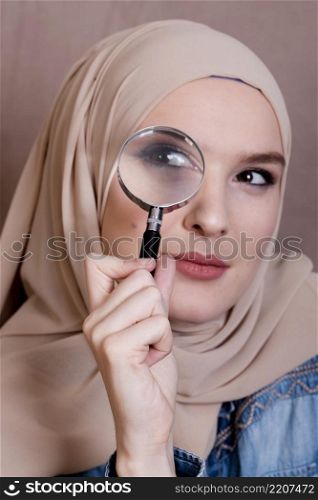 close up curious muslim woman looking through magnifying glass