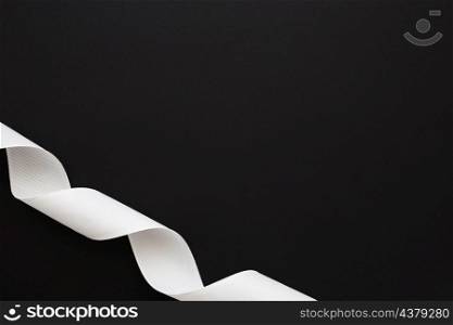 close up curled white ribbon black background corner