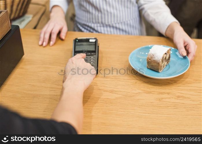 close up customer using pin machine pay bill delicious cake slice