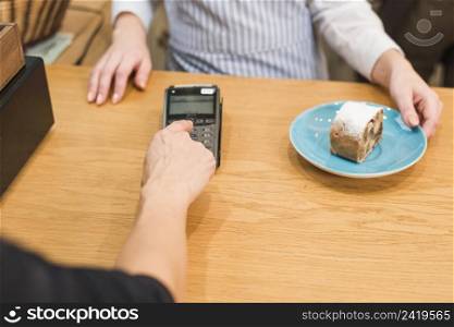 close up customer using pin machine pay bill delicious cake slice
