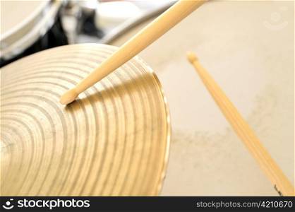 close up cymbal with drumsticks