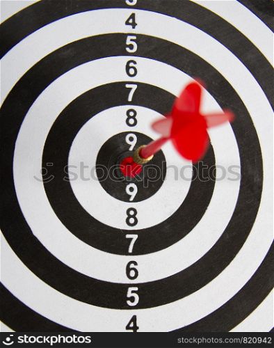 Close-up dart board with a red arrow that hit the center of the target. Darts Board Game