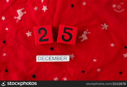 Close-up. December 25 is lined with red cubes along with December lettering on a red Christmas background. Christmas Eve. Close-up. December 25 is lined with red cubes along with December lettering on a red Christmas background. Christmas Eve.