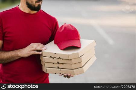 close up delivery guy holding pizza boxes