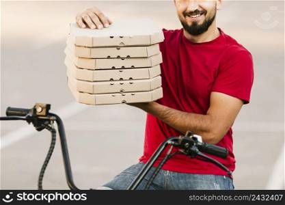 close up delivery man holding pizza boxes