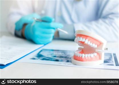 Close up dentures with dentist working on table in clinic.