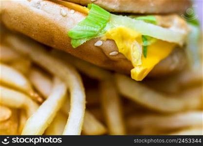 Close up detail of cheeseburger and french fries. Food, junk food and fast food concept