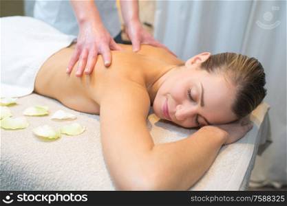 close up detail of hands massaging female shoulder and back
