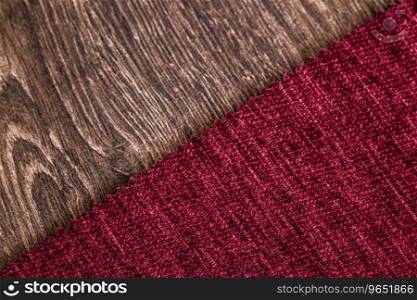 Close up detail of red color fabric texture on wooden background