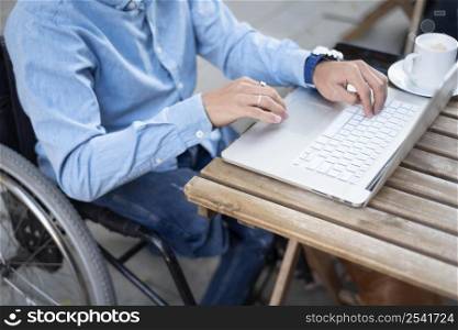 close up disabled man typing laptop