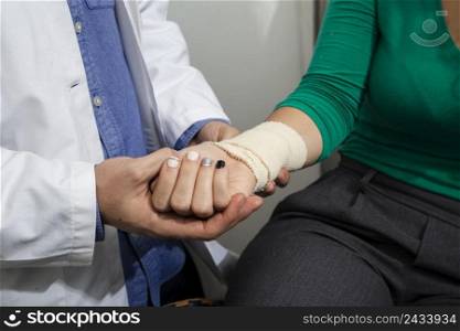 close up doctor checking bandaged arm