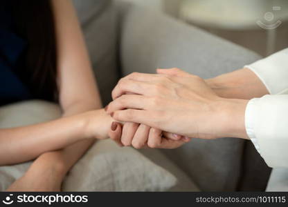 Close-up Doctor hearten, Asian couple join hand to encourage while sitting on the sofa, Health and illness concepts