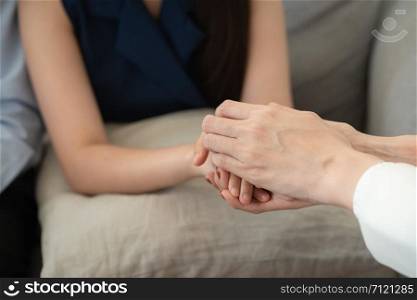 Close-up Doctor hearten, Asian couple join hand to encourage while sitting on the sofa, Health and illness concepts