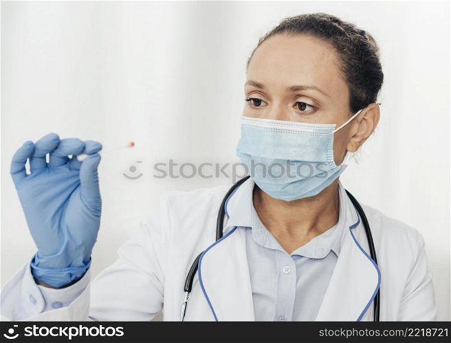 close up doctor holding cotton swab
