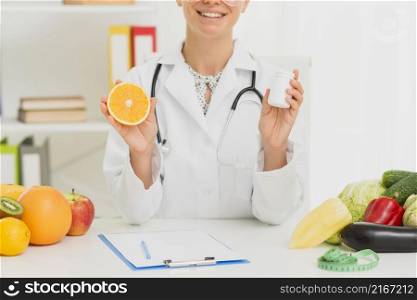 close up doctor holding up half orange