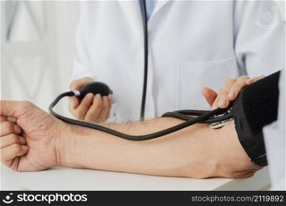 close up doctor inflating blood pressure cuff