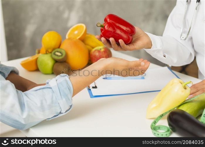 close up doctor patient with red bell pepper