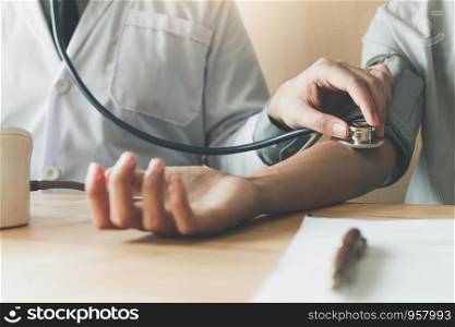 Close up doctor using stethoscope take a tap on the patient's arm in office room.
