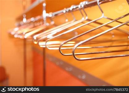 Close up empty metal clothes hangers in row indoor