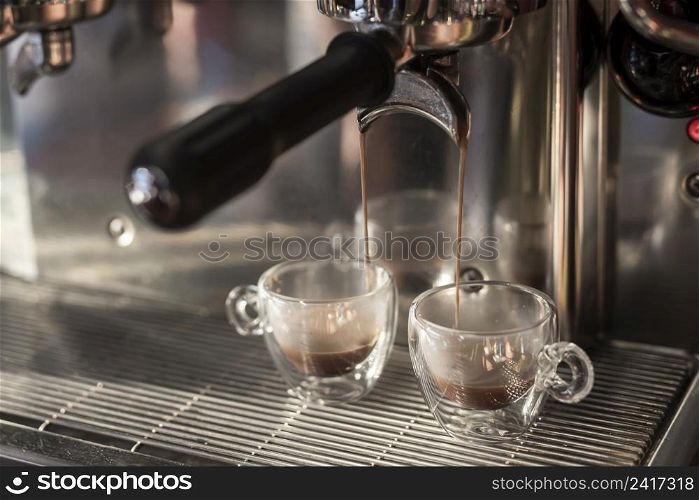 close up espresso pouring into cups