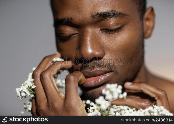 close up expressive man smelling flowers