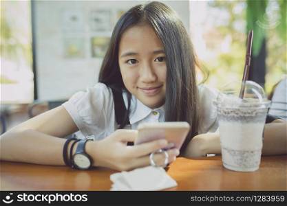 close up face asian teenager happiness smiling face with smart phone in hand