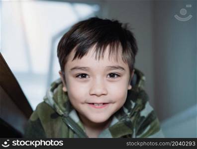 Close up face happy kid boy looking at camera with smiling face, Portrait Cute child wearing fluffy pajamas relaxing at home in the morning