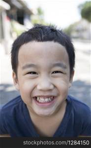 close up face of asian boy with funny milk tooth