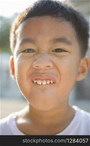 close up face of asian children showing milk tooth