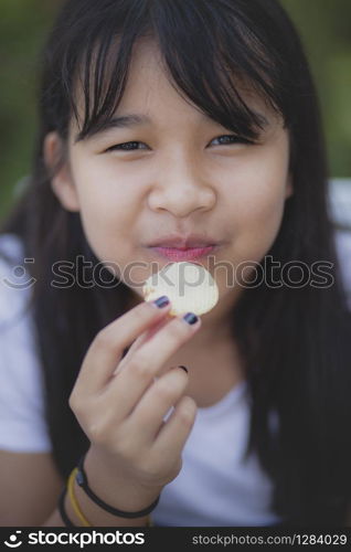 close up face of asian teenager eating snack food with happiness face