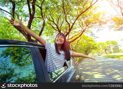 close up face of asian teenager happiness emotion in personal car against green environment of urban town street
