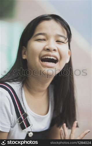 close up face of asian teenager laughing with happiness emotion