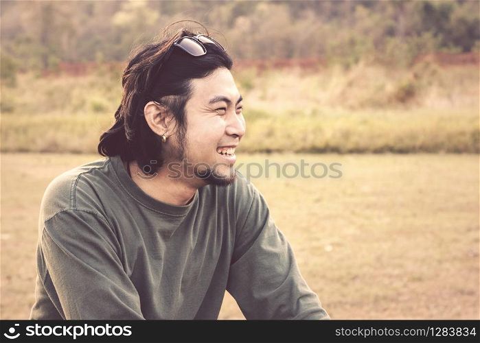 close up face of younger asian man laughing happiness emotion