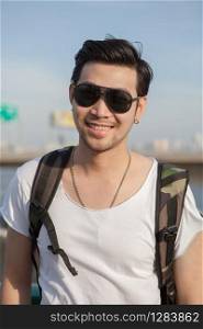 close up face of younger asian man wearing sun glasses standing outdoor