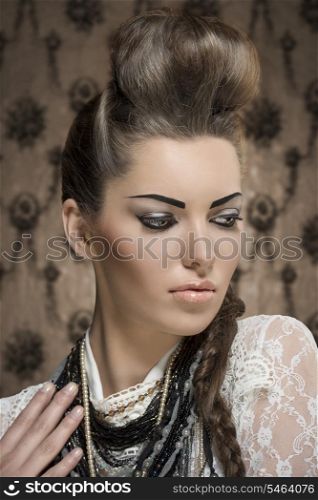 close-up fashion portrait of charming female with creative look, cute brunette hair-style and strong make-up. Wearing white lace shirt and a lot of necklaces