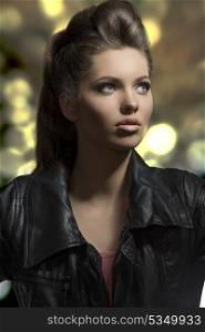 close-up fashion portrait of sensual young girl with brown rock hair-style wearing modern clothes, black leather jacket