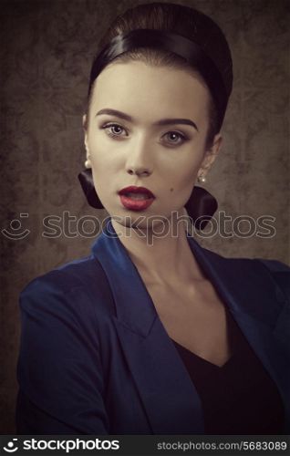 close-up fashion portrait of sexy woman with elegant hair-style, blue jacket and red lipstick.
