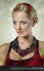 close-up fashion shoot of elegant blonde woman with cute blue make-up and hair-style, wearing dark dress and creative pretty beads necklace