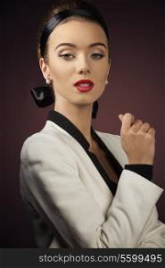 close-up fashion shoot of pretty woman with aristocratic style, elegant hairdo and white jacket, looking in camera